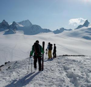 drie mensen lopen over een met sneeuw bedekte berg met ski's bij Hôtel Val d'Este in Saint-Gervais-les-Bains