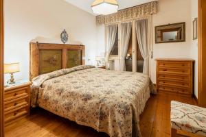 a bedroom with a bed and a dresser and a window at Villa Radiosa - Stayincortina in Cortina dʼAmpezzo