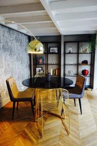 een eetkamer met een glazen tafel en 2 stoelen bij Loft Royal des Promenades in Reims