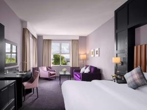 um quarto de hotel com uma cama grande e cadeiras em Radisson BLU Hotel & Spa, Sligo em Sligo