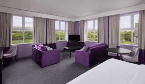 um quarto de hotel com mobiliário roxo e janelas em Radisson BLU Hotel & Spa, Sligo em Sligo