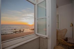 a room with a window with a view of the beach at Liiiving in Porto - Luxury Beachfront Apartments in Porto