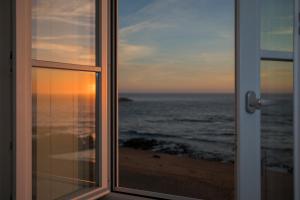 a view of the ocean from a window at Liiiving in Porto - Luxury Beachfront Apartments in Porto