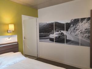 シャルトル・ド・ブルターニュにあるThe Originals Boutique, Hôtel La Chaussairie, Rennes Sudの壁に車の絵が描かれたベッドルーム