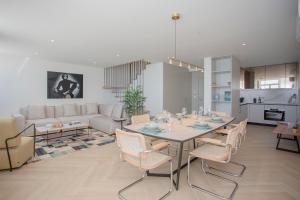 a dining room and living room with a table and chairs at Liiiving in Porto - Luxury Beachfront Apartments in Porto