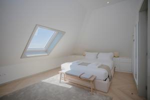 a white room with a bed and a window at Liiiving in Porto - Luxury Beachfront Apartments in Porto