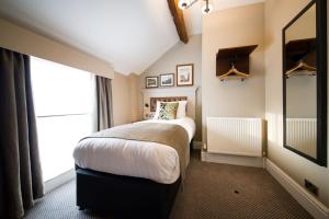 een slaapkamer met een bed en een groot raam bij The St George and Dragon by Innkeeper's Collection in Topsham