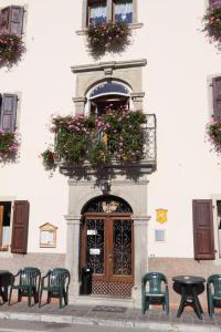 a building with a door with a balcony with flowers at Albergo Alle Alpi in Comeglians