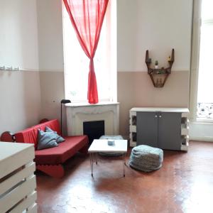 uma sala de estar com um sofá vermelho e uma lareira em La Maïoun Guesthouse em Nice