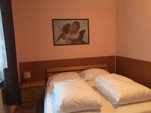 a bedroom with two beds with a picture on the wall at Penzion T&T in Cheb