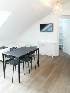 a dining room with a black table and chairs at Sissi Apartments in Achau