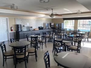 um restaurante com mesas e cadeiras e uma cozinha em Galveston Beach Hotel em Galveston