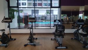 un gimnasio con bicicletas estáticas y una piscina en Conezion Luxury 3BR for 7pax @IOI Resort Putrajaya, en Putrajaya