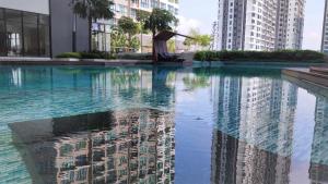 una piscina de agua en una ciudad con edificios altos en Conezion Luxury 3BR for 7pax @IOI Resort Putrajaya, en Putrajaya