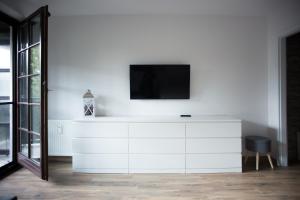 een witte dressoir met een televisie erop bij Apartament Kameralny in Kazimierz Dolny