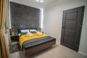 Apartament w Cieplicach Deluxe في يلينيا غورا: غرفة نوم بسرير وجدار من الطوب