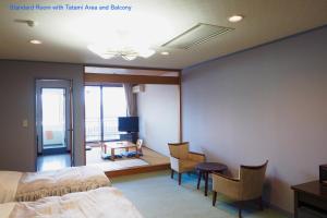 um quarto de hotel com uma cama, uma mesa e cadeiras em Shoji Mount Hotel em Fujikawaguchiko