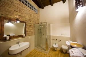 uma casa de banho com um chuveiro, um lavatório e um WC. em Castelletto Suites em Cagliari