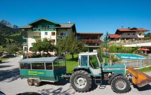 um tractor verde estacionado em frente a um edifício em Wohlfühlresort und Feriengut Martinerhof em Sankt Martin am Tennengebirge