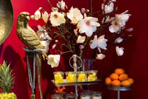 un vase de fleurs et un oiseau sur une table avec des oranges dans l'établissement Hotel im Hof, à Munich