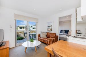 een keuken en een woonkamer met een bank en een tafel bij The Victoria Apartments in Port Fairy