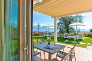 d'une terrasse avec une table et des chaises. dans l'établissement La Chioma di Berenice Garda Residence, à Toscolano Maderno