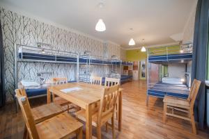 a dining room with a table and chairs and bunk beds at Atlantis Hostel in Kraków