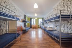 a room with three bunk beds and a dining room at Atlantis Hostel in Kraków