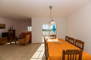 uma sala de jantar e sala de estar com mesa e cadeiras em Blue Villa by ALGARVEMANTA na Manta Rota