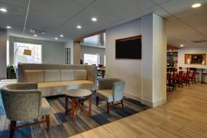 a waiting room with a couch and chairs and a tv at Holiday Inn Express Baltimore BWI Airport West, an IHG Hotel in Hanover