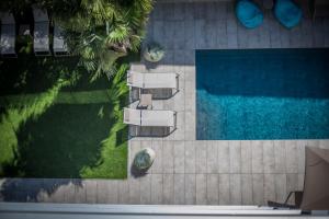 - une vue sur la piscine avec des chaises et une pelouse dans l'établissement Hotel Villa Enrica, à Riva del Garda