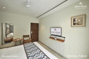 a bedroom with a bed and a sign on the wall at Meritas Adore Resort in Lonavala