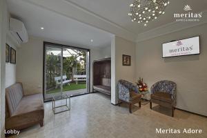 a living room with two chairs and a large window at Meritas Adore Resort in Lonavala