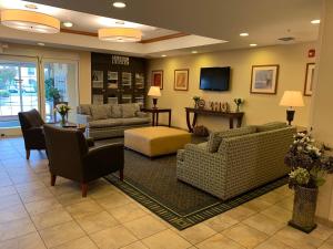 a waiting room with couches and chairs and a television at Candlewood Suites Jonesboro, an IHG Hotel in Jonesboro