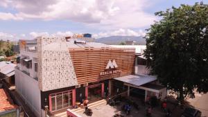 Vue de tête d'un bâtiment avec un panneau sur celui-ci dans l'établissement Merlin Hotel, à Maumere