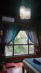 una camera da letto con finestra e lampadario pendente di Halo Bay Homestay a Ha Long