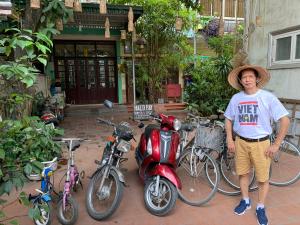 Un uomo è in piedi accanto a un gruppo di moto di Halo Bay Homestay a Ha Long