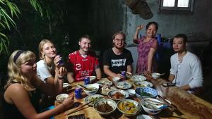 un gruppo di persone seduti intorno a un tavolo con cibo di Halo Bay Homestay a Ha Long