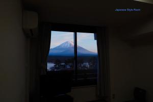 uma vista para uma montanha através de uma janela em Shoji Mount Hotel em Fujikawaguchiko