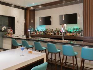 a bar in a restaurant with blue chairs at Pan Pacific Toronto in Toronto