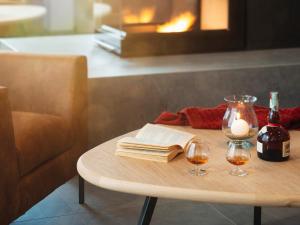 a table with a book and two glasses of wine at Red Fox Lodge in Breuil-Cervinia