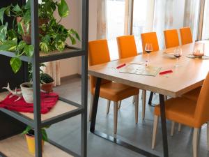 a dining room with a table and orange chairs at Red Fox Lodge in Breuil-Cervinia