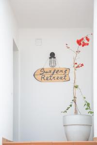 a sign on a wall next to a vase with a plant at Surfers Retreat in Corralejo