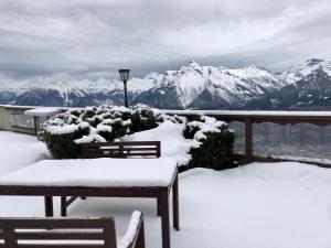 einen Balkon mit schneebedeckten Stühlen und Bergblick in der Unterkunft Hôtel Chalet Royal in Veysonnaz