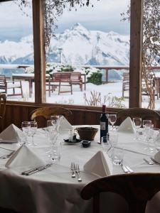 ein Tisch mit Gläsern und eine Flasche Wein darauf in der Unterkunft Hôtel Chalet Royal in Veysonnaz