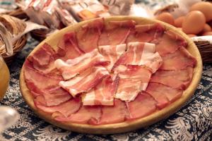 una pizza al prosciutto seduta sopra un tavolo di Hotel Terme a Bormio