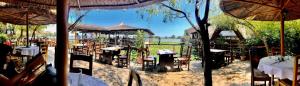 un restaurant avec des tables, des chaises et des parasols dans l'établissement Hotel Insula, à Legian