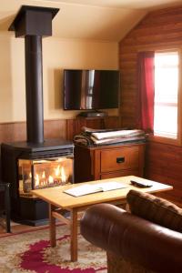 - un salon avec une cuisinière et une cheminée dans l'établissement Hillside Bungalows, à Banff