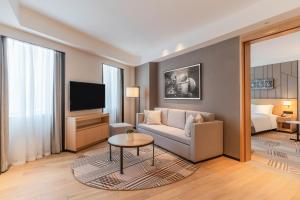 uma sala de estar com um sofá e uma televisão em Hyatt Place Changchun Jingyue em Changchun