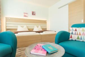 1 Schlafzimmer mit einem Bett, einem Tisch und 2 Stühlen in der Unterkunft Hotel Peterhof - urban lifestyle Kempten in Kempten